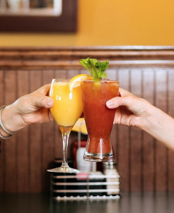Two patrons toasting with Mimosa and Bloody Mary.