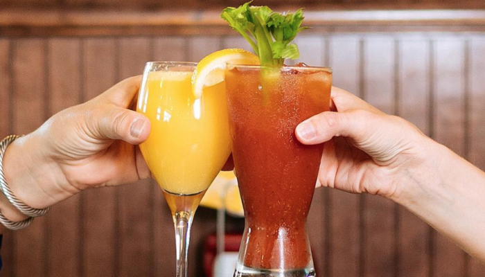 Two patrons toasting with Mimosa and Bloody Mary.