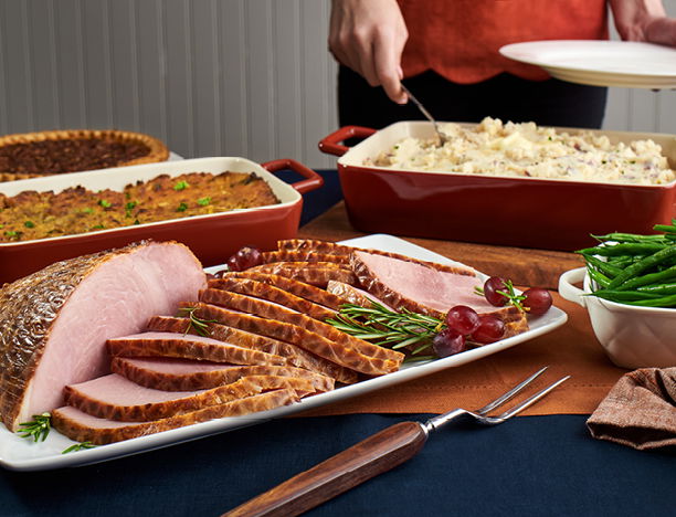 A tray of ham, with stuffing, pie, mashed potatoes and green beans