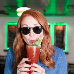 Woman with sunglasses on sipping bloody mary