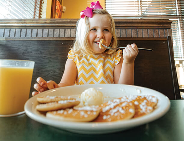 child eating pancakes